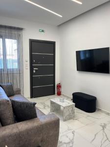 a living room with a couch and a flat screen tv at Salamina Downtown Apartment East in Salamina