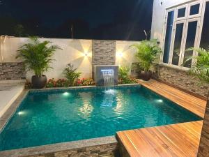 a swimming pool in a backyard at night at The Palm Grove Farm Villa in Greater Noida +26 photos