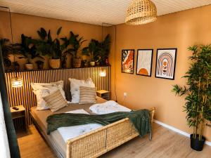 a bedroom with a bed with plants on the wall at Ruhiges & gemütliches Studio in Schneverdingen