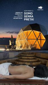 a woman laying on a bed in front of a dome tent at Natureza e luxo in Alagoa Nova +3 photos