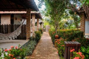 a brick walkway in front of a house with flowers at Hotel Pousada Rancho das Dunas in Santo Amaro
