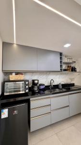 a kitchen with a sink and a microwave at Natureza e luxo in Alagoa Nova
