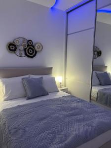a bedroom with a large bed and a mirror at Salamina Downtown Apartment East in Salamina
