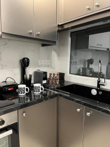 a kitchen with stainless steel cabinets and black counter tops at Salamina Downtown Apartment East in Salamina +4 photos