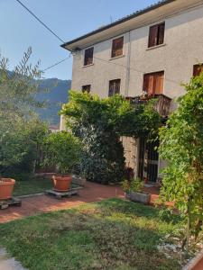 a building with a yard with benches in front of it at La Casa di Giovanni B&B in Romano D'Ezzelino