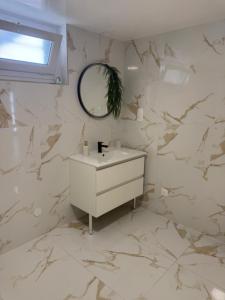 a white bathroom with a sink and a mirror at Maison Charmante in Donges +12 photos
