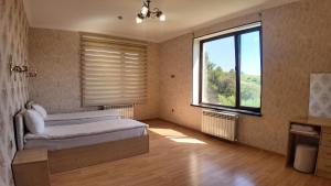 a bedroom with a bed and a large window at Sadaxlı Hotel & Restaurant in Şǝrǝdil