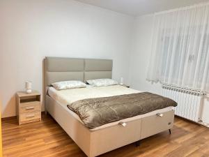 a bedroom with a large bed in a white room at Garden View Apartment in Čapljina