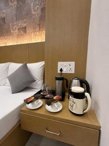 a bed with a coffee maker on a table next to a bed at Hotel Rose Inn in Prayagraj