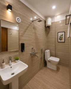 a bathroom with a sink and a toilet and a mirror at Hotel Rose Inn in Prayagraj +29 photos