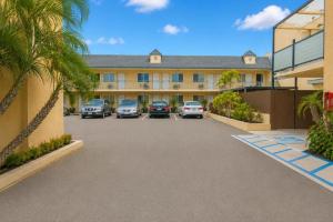 a parking lot in front of a building with parked cars at Del Playa Inn Oxnard Near Camarillo in Oxnard