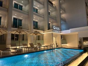 a hotel swimming pool in front of a building at Hotel Oasis in Sarandë