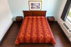 a bedroom with a bed with a red blanket at Del Playa Inn Oxnard Near Camarillo in Oxnard