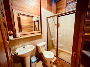a bathroom with a toilet and a sink and a shower at Huayra Wasy in Tena +7 photos