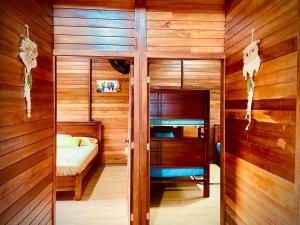 a bedroom with a bunk bed and wooden walls at Huayra Wasy in Tena