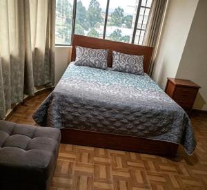 a bedroom with a bed and a couch and a window at Hostal acacias in Cuenca +5 photos