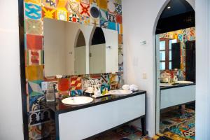 ein Badezimmer mit zwei Waschbecken und einem großen Spiegel in der Unterkunft Del Carmen Concept Hotel Boutique by Chai in Guadalajara + 246 Fotos
