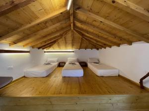 two beds in a room with wooden floors at Faos residence I in Pefkias