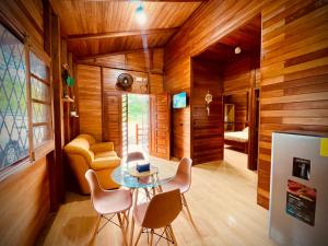 a room with wooden walls and a table and chairs at Huayra Wasy in Tena