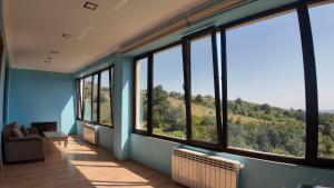 a room with large windows with a view of a hill at Sadaxlı Hotel & Restaurant in Şǝrǝdil