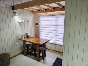 ein Holztisch in einem Zimmer mit Fenster in der Unterkunft dormitorio REST in Chaitén
