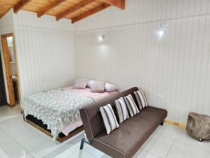 ein Schlafzimmer mit einem Bett und einer Couch in der Unterkunft dormitorio REST in Chaitén