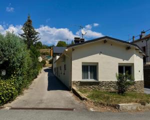 a small white house with a road next to it at Casa Pont in Osséja