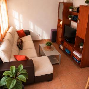 a living room with a couch and a tv at Encanto Rural in Arnedillo