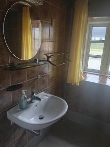 a bathroom with a sink and a mirror and a window at Vesterhavet in Nørre Vorupør