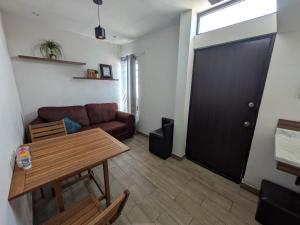 a living room with a couch and a table and a door at Zona nuevo CAMPUS Universidad departamento independiente in Chihuahua