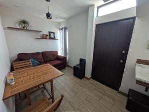 a living room with a couch and a table and a door at Zona nuevo CAMPUS Universidad departamento independiente in Chihuahua