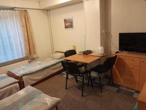 a room with a table and a bed and a tv at Pokoje Slomkowscy in Łódź +9 photos