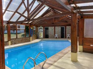 a large swimming pool with a wooden ceiling at Cabañas Mapuche in Esquel
