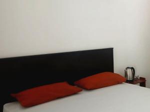 a bed with two red pillows on top of it at Ceylon Salt & Soul in Arugam Bay +11 photos