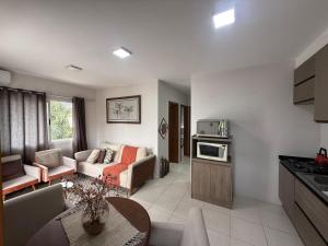 a kitchen and living room with a couch and a table at Apartamento Unisc in Santa Cruz do Sul