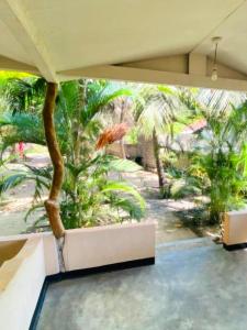 a room with a table and a palm tree at Ceylon Salt & Soul in Arugam Bay