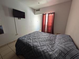a bedroom with a bed and a red curtain at Departamento privado zona de la UACH in Chihuahua