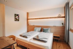 a bedroom with a bed with white sheets and blue pillows at Innersennerhof in Rifiano
