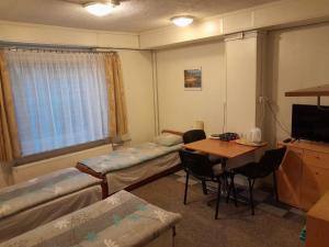 a room with beds and a table and a desk at Pokoje Slomkowscy in Łódź
