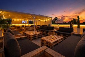 an outdoor patio with couches and tables and a television at Casa roof in Las Terrenas