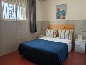 a bedroom with a large bed with a blue blanket at Apartamento Casa Balina in Dúrcal