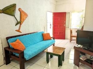 a living room with a blue couch and a red door at Simberts Apartments in Maya Beach