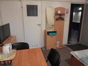 a room with a table and chairs and a kitchen at Pokoje Slomkowscy in Łódź
