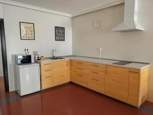 a kitchen with wooden cabinets and a white refrigerator at Apartamento Casa Balina in Dúrcal