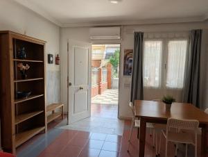 a dining room with a wooden table and a door at Apartamento Casa Balina in Dúrcal