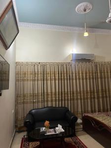 a living room with a black chair and a table at Faran inn guest house in Hyderabad