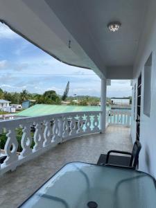 a balcony with a bed and a view of a tennis court at The Ansen Place in Belmopan