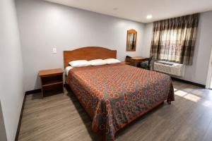 a hotel room with a bed and a window at Stay Inn Checotah near Eufaula Lake in Checotah