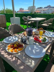 a picnic table with plates of food on it at Noa Hotel Velipoje in Velipojë