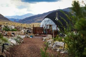 a large greenhouse with a bench and mountains in the background at Pure Heart Retreat in Cody +64 photos